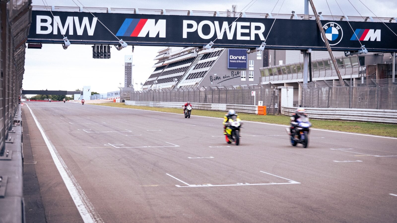 Motorcycles race on a track under the BMW banner